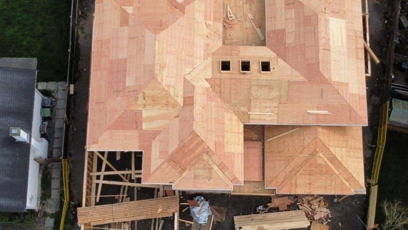 A complex hip roof sheathed and ready for roofing, seen from above.