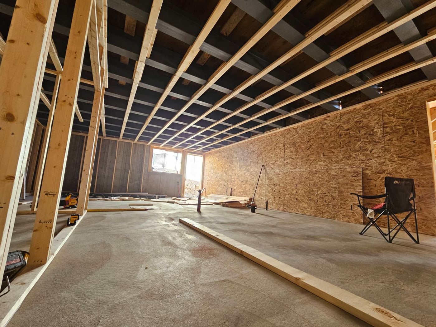 Ceiling framing and sheathed interior walls inside a lower level.