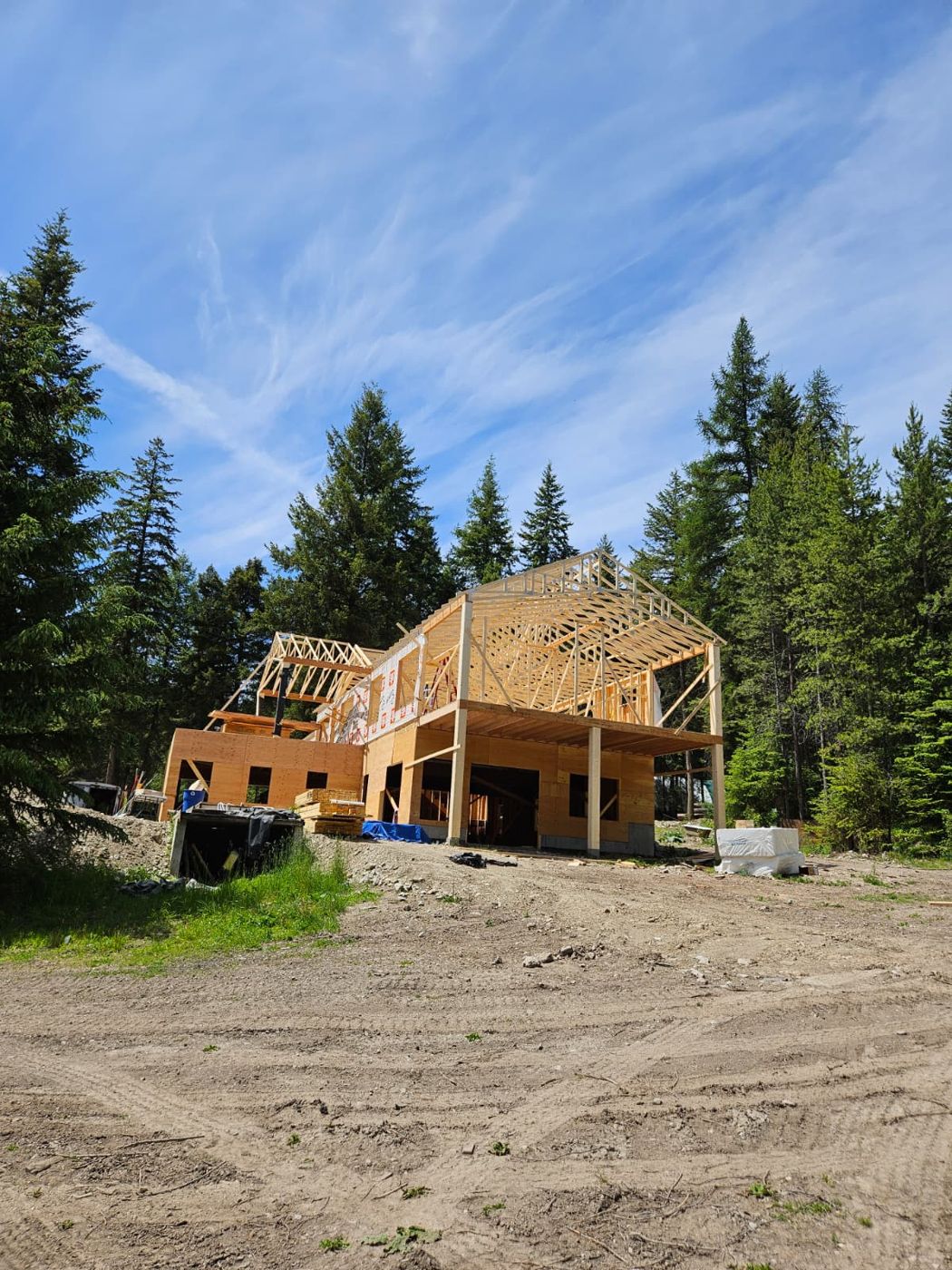 Hillside home framed by 4Rise with floor system, glulam posts and roof trusses under a blue sky